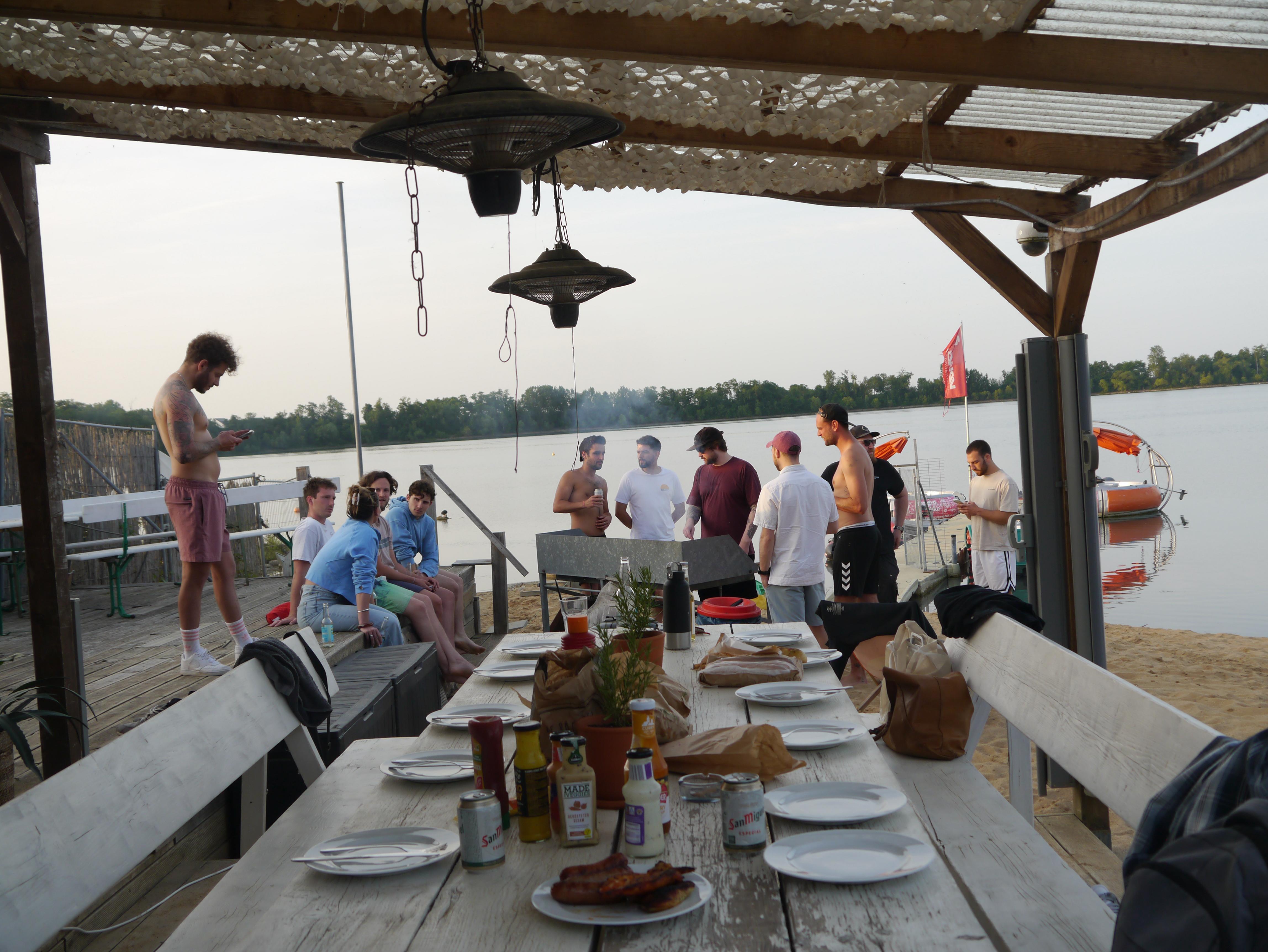 Grillabend mit Freunden am See im Sonnenuntergang